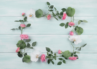 Wooden background with floral frame consists of roses and orchid flowers © julia_arda