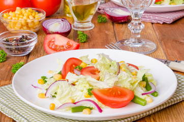 Salad with Chinese cabbage, tomatoes, corn, green beans and onion. Healthy dish.
