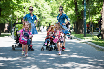 Fototapeta premium twins mother with children in city park