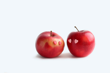 Two lovely red apples with hearts eyes on white background. fresh fruit apple. symbol of love, Valentine's day. creative minimal style. element for design. copy space