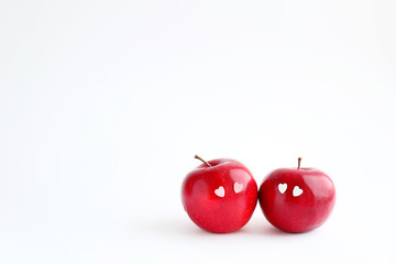 Two lovely red apples with hearts eyes on white background. delicious fresh fruit apple. symbol of love, Valentine's day. minimal style. element for design. copy space