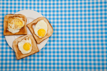 Breakfast. Toast and eggs on a blue table