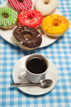 Colorful donuts and cups of coffee on blue table