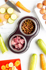 petfood set with vegetables and meat on kitchen table background top view
