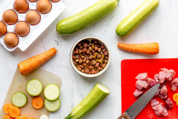 Dogfood set with cut vegetables and knife on table background top view