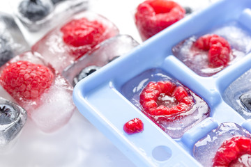 Fototapeta na wymiar Ice tray with berries on white background