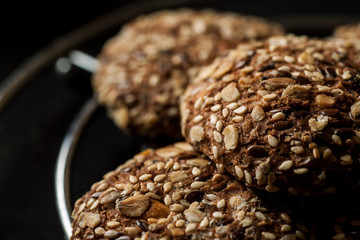 Homemade oatmeal cookies with nuts and seeds on a metal stand with other stuff, closeup shot