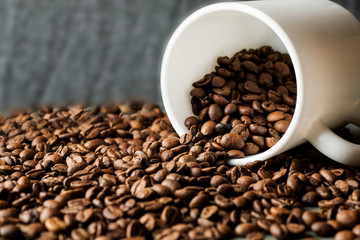 White ceramic mug with coffee beans on wooden table