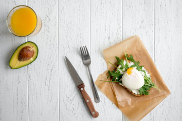 sandwich with poached eggs on wooden background top view