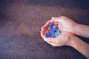 hands holding blue ribbons, toning background