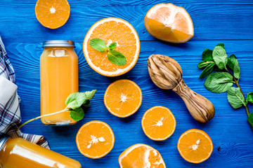 Orange juice in bottle with slices and mint on table top view