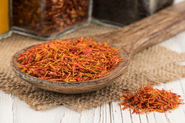 Fototapeta premium Saffron in a wooden spoon and an old white wooden table.
