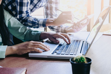 Business team using laptop computer and notebook to work with financial data.Close up.Business analysis and strategy concept.