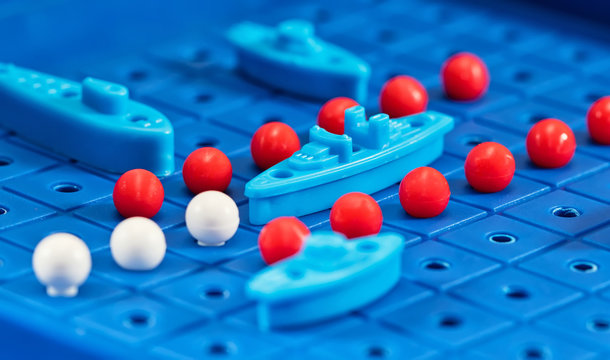 Toy war ships and submarine are placed on the blue  playing Board