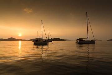 Obraz na płótnie Canvas moored sailboats at sunset, Kornati, Croatia