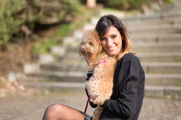Beautiful young woman with her dog in a park