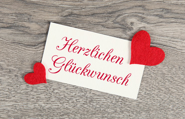 Herzen auf Holzhintergrund: Herzlichen Gl&uuml;ckwunsch!