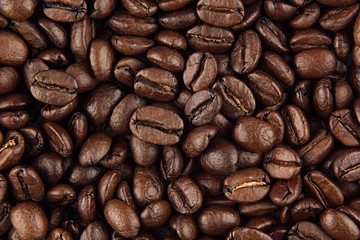 Roasted coffee beans closeup top view as background.