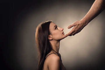 Male hand touches to woman face as Sexual Harassment - obrazy, fototapety, plakaty