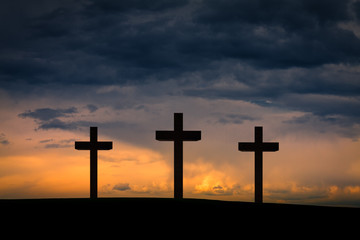 Jesus Christ cross between two crosses on Golgota Mountain, on  blue, orange, purple sky with...