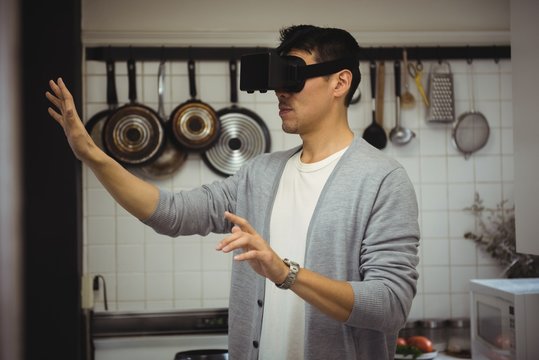 Man experiencing virtual reality headset in kitchen