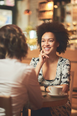 Female friends having coffee, smiling and gossip.