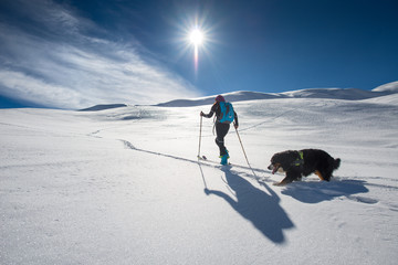 Girl makes ski mountaineering with his dog in a fairy-tale place