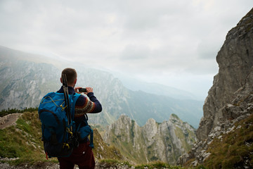 Man hiking in the mountains photographing nature