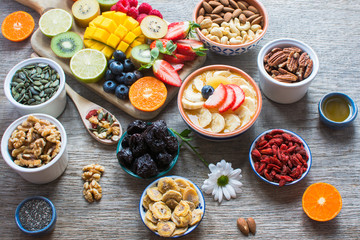 Smoothies made with satsumas, golden kiwis, mango and banana with fruits and berries on the wooden table, selective focus