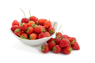 Fresh ripe strawberries in small white bowl on white background.