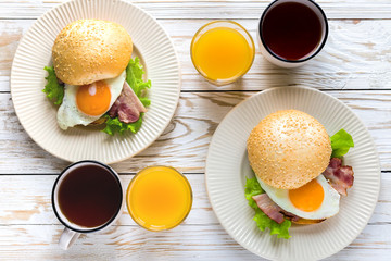 Burger sandwich, cup of tea and orange juice for breakfast