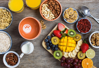 Fototapeta na wymiar Healthy and various morning breakfast selection: cereals, nuts, fruits, juice, berries, selective focus. Top view