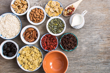 Ingredients for healthy granola: nuts, oats, cereals and dried fruits, top view, selective focus