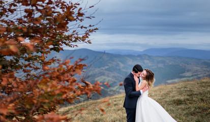 The lovely couple in love embracing near tree