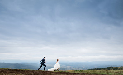 Obraz premium The charming brides running along field