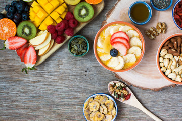 Smoothies made with satsumas, golden kiwis, mango and banana with fruits and berries on the wooden table, top view, selective focus