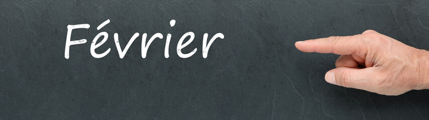 Obraz premium Février à la craie et montrer du doigt sur ardoise