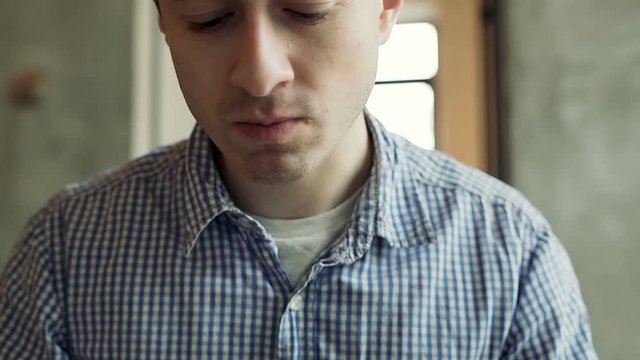 Young man in checked shirt using cutlery while eating healthy lunch
