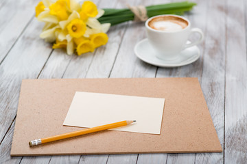  cup of coffee next to spring white flowers on wooden texture
