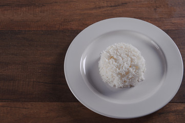 White rice in plate on wooden table