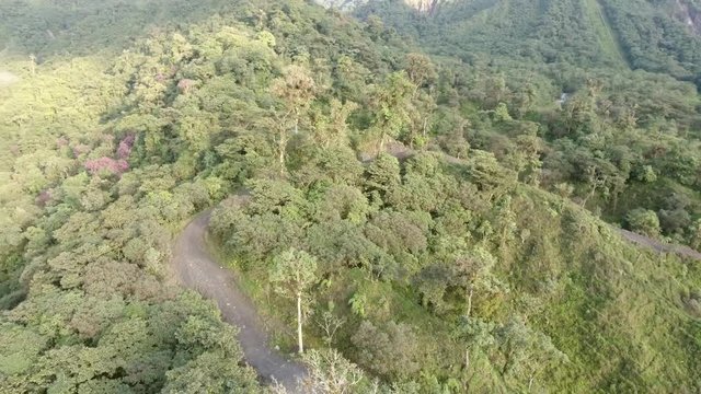 Flying above a dirt road being cut into montane rainforest near Reventador Volcano in the Ecuadorian Amazon. Now pristine, the road will bring in colonists, cattle ranchers and the forest will be cut.