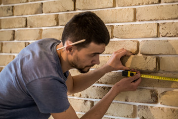 male works with brick wall with centimeter