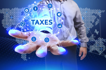 Business, Technology, Internet and network concept. Young businessman shows the word on the virtual display of the future: Taxes
