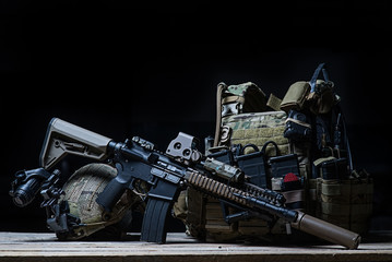 Rifle with silencer, bulletproof vest, helmet/Assault rifle with silencer, bulletproof vest, helmet with night vision device on dark background - obrazy, fototapety, plakaty