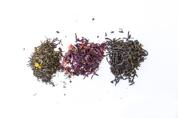Dry leaves of black and green tea and red on a white background