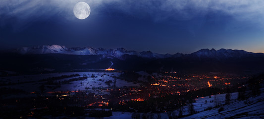 Magic night view on illuminated Zakopane city by moonlight buried