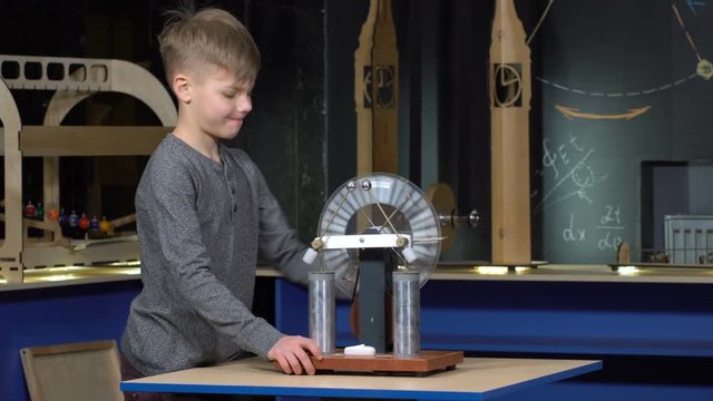 The boy turns the electrostatic machine