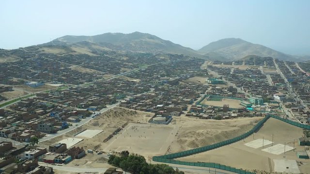 Ventanilla Peru Aerial v24 Flying low over urban poverty hillside housing area.