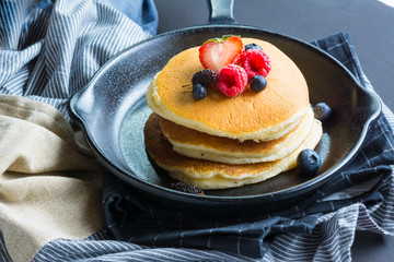Pancakes with blueberries  & raspberry on wood background