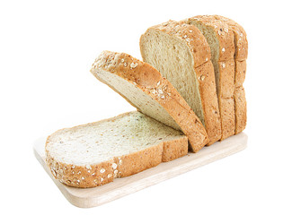 whole grain bread and slices on wooden cutting board and on white background